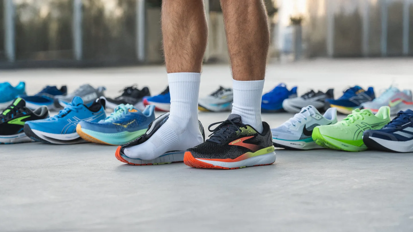Farklı spor ayakkabılar arasında seçim yapan kişi, koşu ve spor için ayakkabı denemesi yapıyor